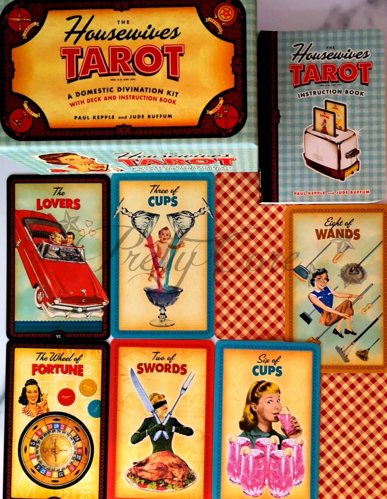 Housewives tarot box and cards, gingham print with 1950s fashioned pictures such as the lovers, eight of wands with the cartoon style imagery from this era