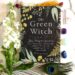 The Green Witch Book by Arin Murphy-Hiscock with flowers, crystals and peacock feather around the book