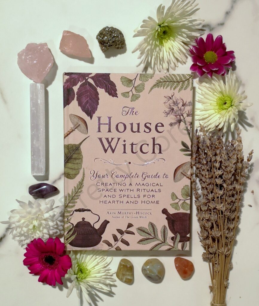 The House Witch by Arin Murphy-Hiscock surrounded by flowers, lavender and crystals