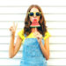 Fashion cool girl eating a slice of watermelon in the form of ice cream on a white background