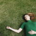 Woman lying on the grass facing up trying to find your inner calm