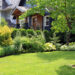 Beautiful home surrounded by a lush perennial front garden. hedge trimming healthy yard