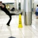 Man slips next to Wet Floor sign slip free shoes
