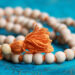 prayer beads with orange thread on blue background to Honor Your Faith Through Religious Jewelry