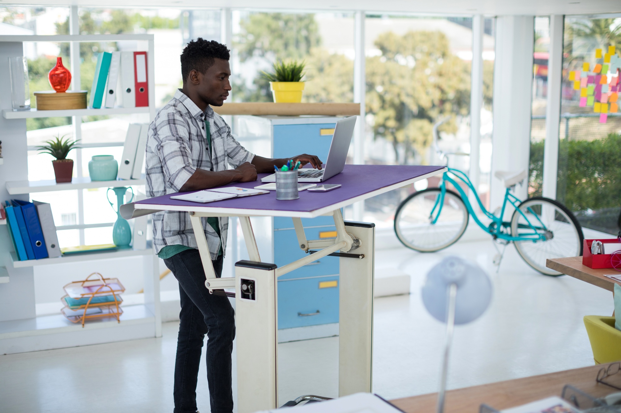 Male working on a stand up desk which is making a computer desk look good