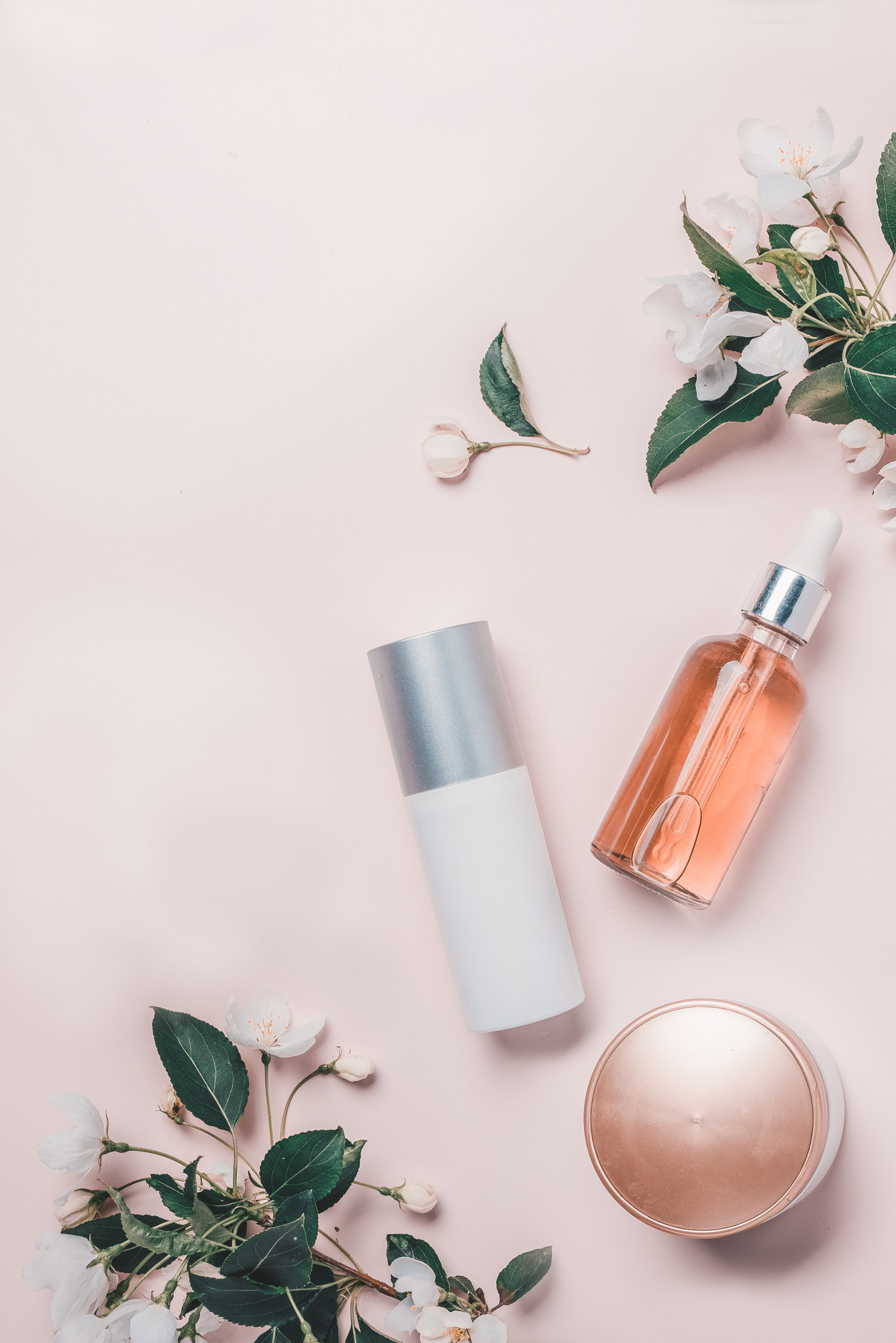 Pink natural cosmetics: oil, serum, cream, mask on background with flowers. Flat lay, Spa concept for Skincare ingredients to avoid