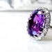 Large amethyst/purple gemstone ring with white stones around for a guide to buying gemstones