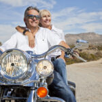 Senior couple on desert road sitting on motorcycle as they met using local dating sites
