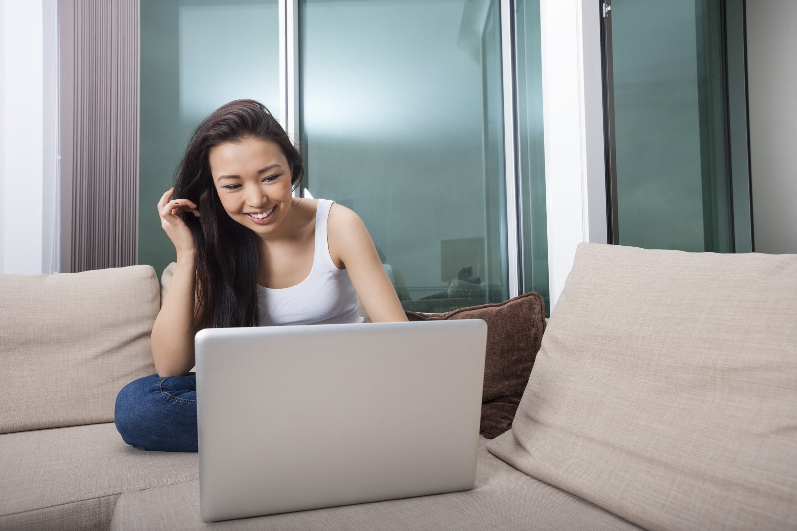 Woman sat on the sofa with a laptop in front of her A Guide On How To Date During A Lockdown - 5 Lockdown Dating Tips