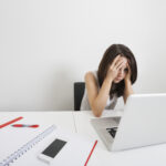 Woman looking stressed with her head in her hands