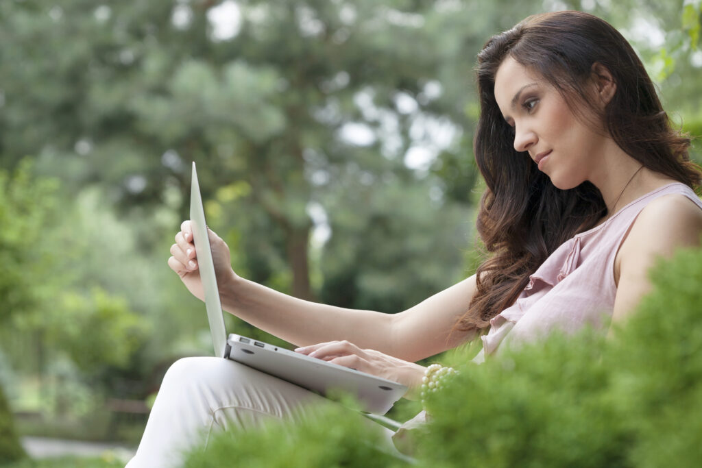 Woman sat in a field with her laptop Become An Online Virtual Dating Master - 4 Tips For Becoming A Dating Virtuoso