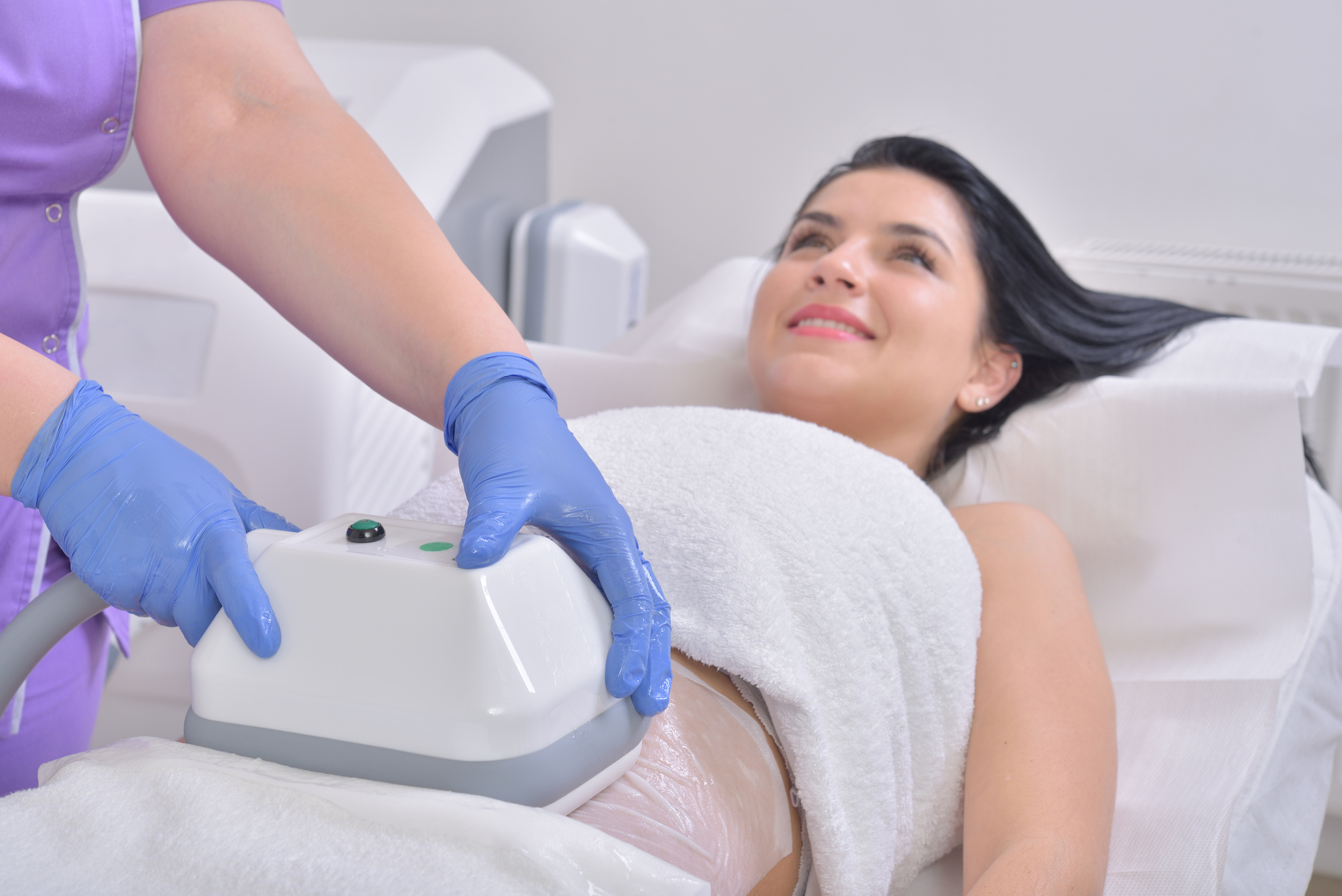 Pretty young woman getting cryolipolyse treatment in professional cosmetic cabinet What Are the Benefits of CoolSculpting and Is It Right for You?